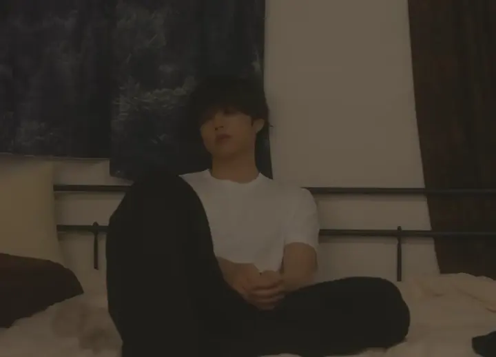 어두운 방 침대에 앉아 있는 선우